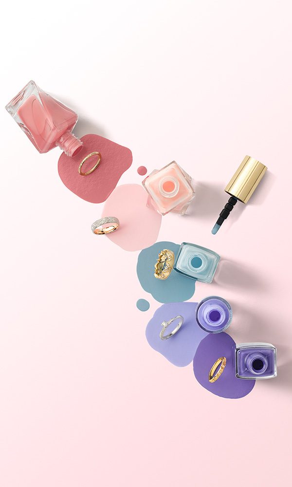 Ringdesigns kombiniert mit Nagellack in Rosé, Blau und Flieder – ein stilvolles Flatlay für die Hochzeitsvorbereitung.
