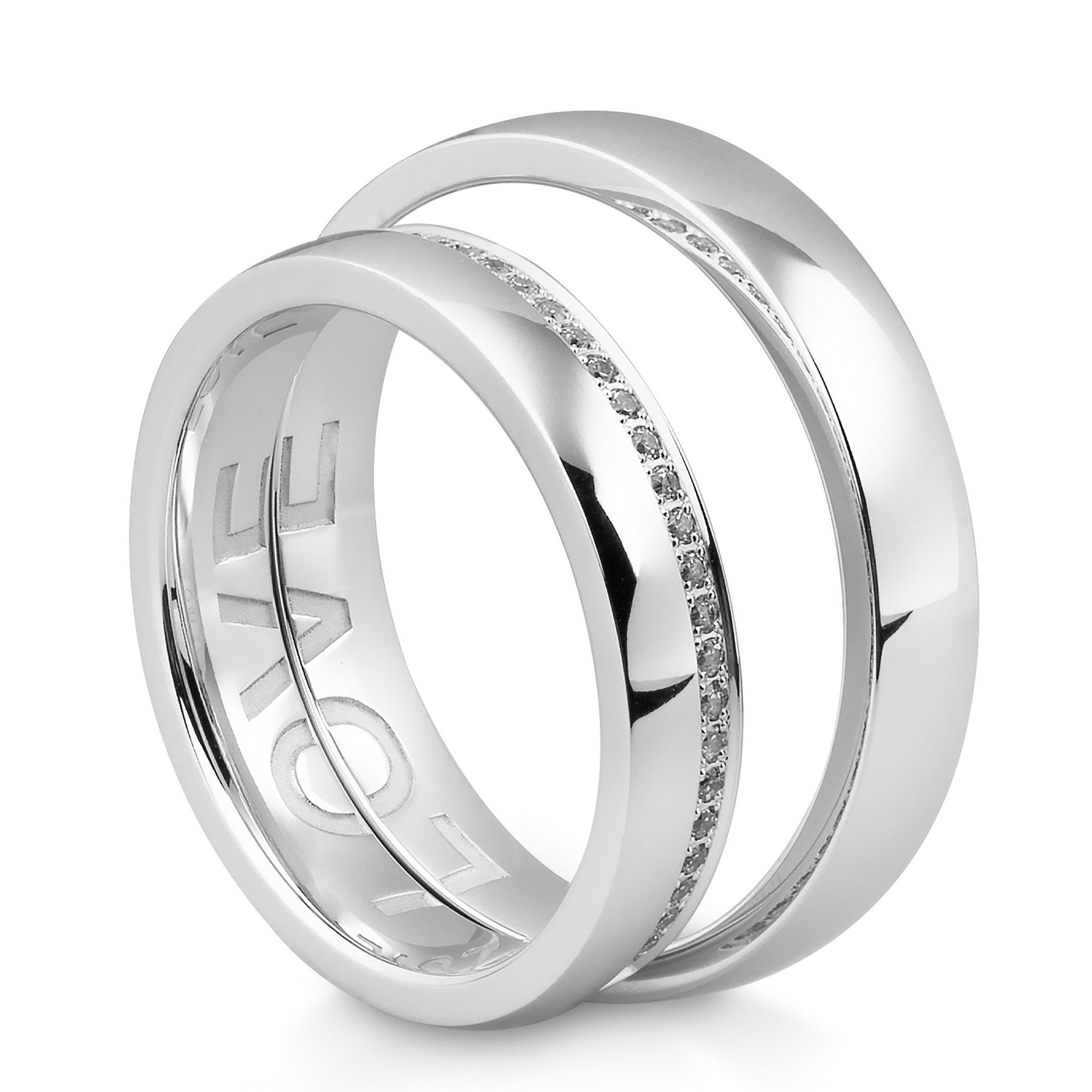 Zwei glänzende Weißgoldringe, einer mit einer feinen Diamantreihe und der andere mit einer minimalistischen, glatten Oberfläche. Das Wort "LOVE" ist auf der Innenseite des einen Rings eingraviert.