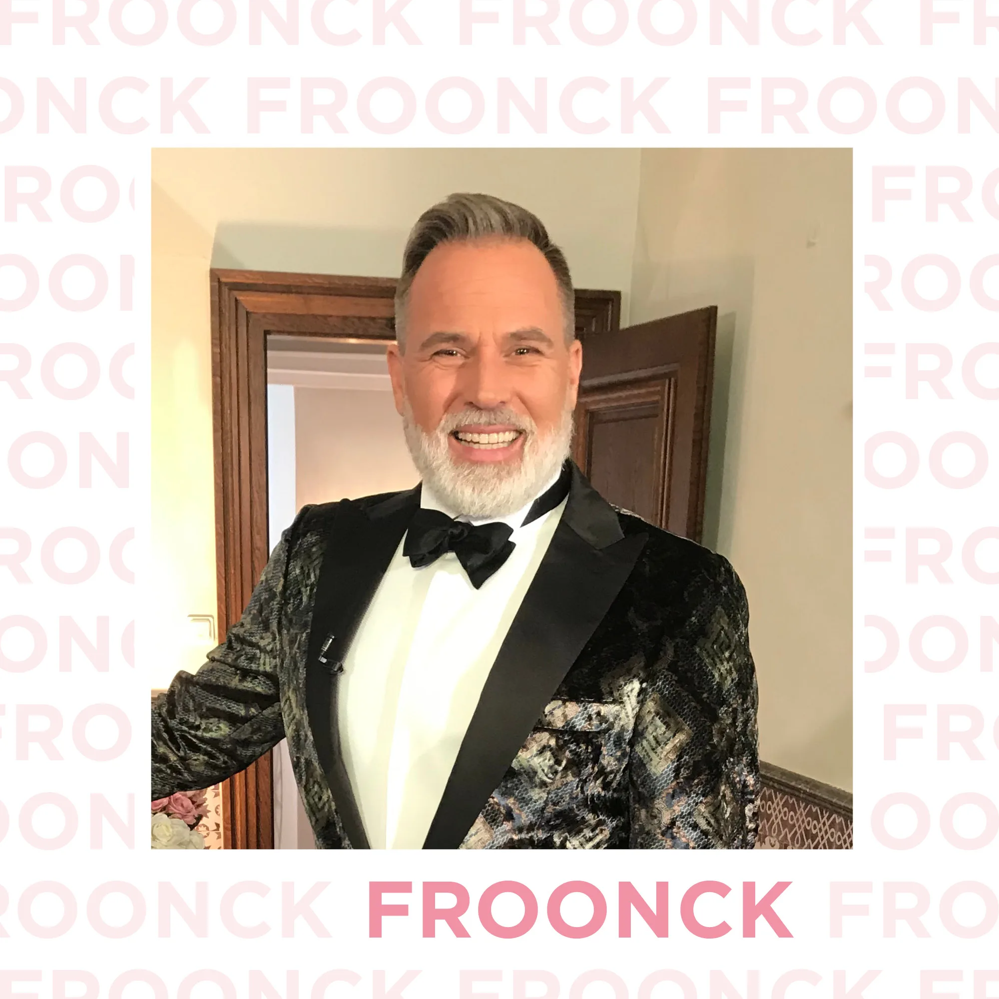 Der bekannte Hochzeitsplaner Froonck trägt einen eleganten schwarzen Smoking und posiert in einem stilvollen Interieur. Mit einem strahlenden Lächeln begrüßt er die Zuschauer und zeigt seine Expertise.