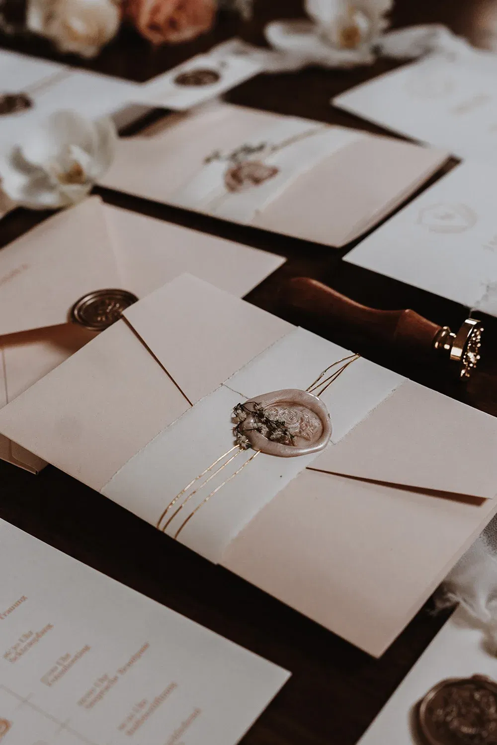 Papeterie für eine Hochzeit mit Wachssiegeln und Goldfäden. Die feinen Details und das Siegel verleihen den Umschlägen eine luxuriöse Note.