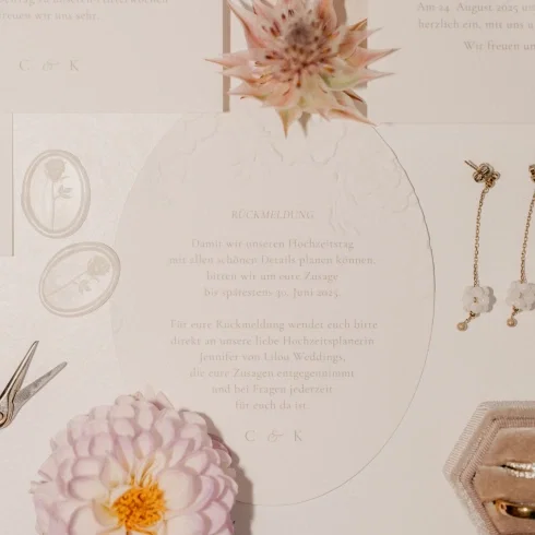 Elegante Hochzeits-Papeterie mit geprägter Karte und Platzschild „Madleen“, dekoriert mit Trockenblumen und Siegelstempel in zarten Rosé- und Cremefarben.