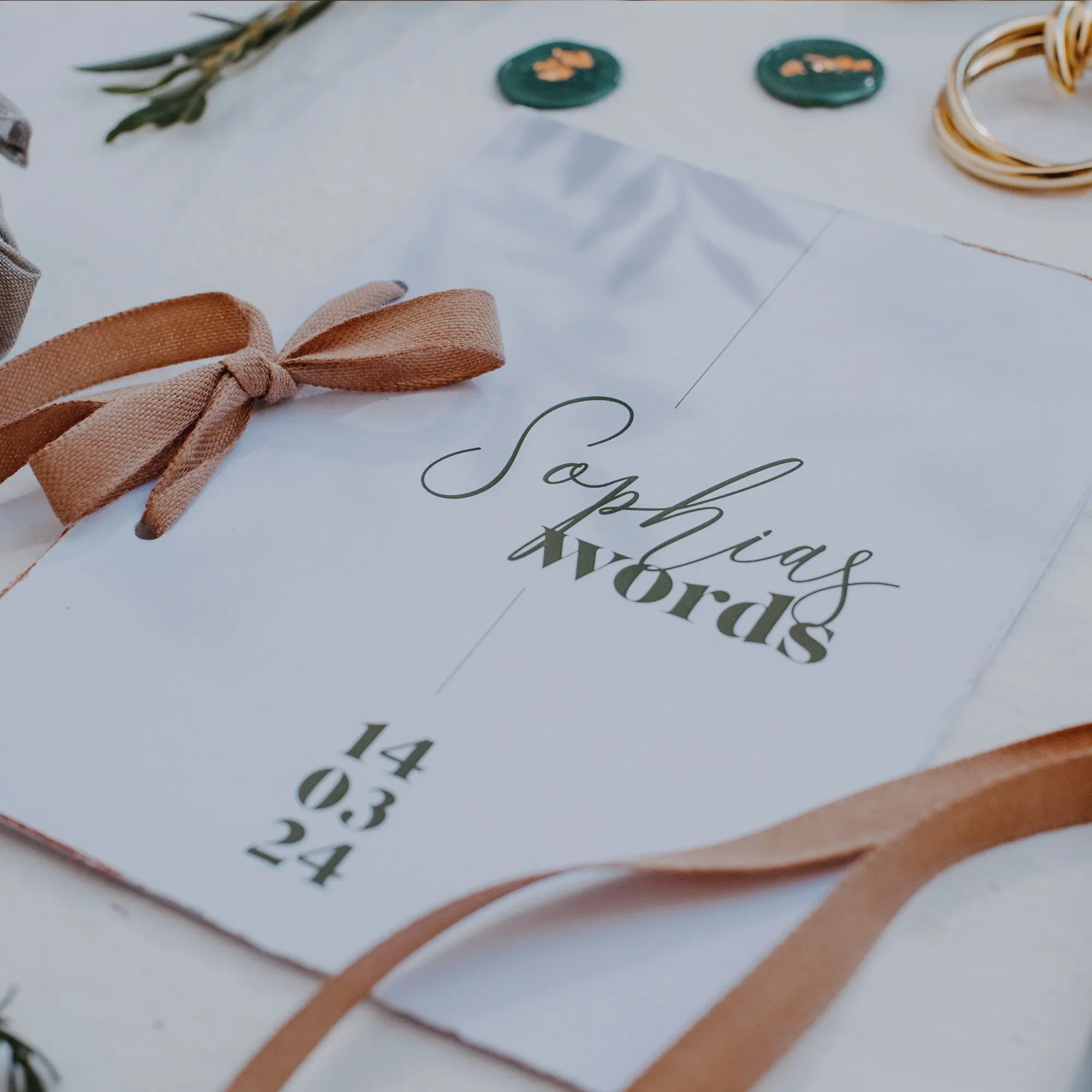 Stilvoll gestaltetes Ehegelübde in zarten Farben, dekoriert mit einem Schleifenband und kleinen floralen Details für die Hochzeit.