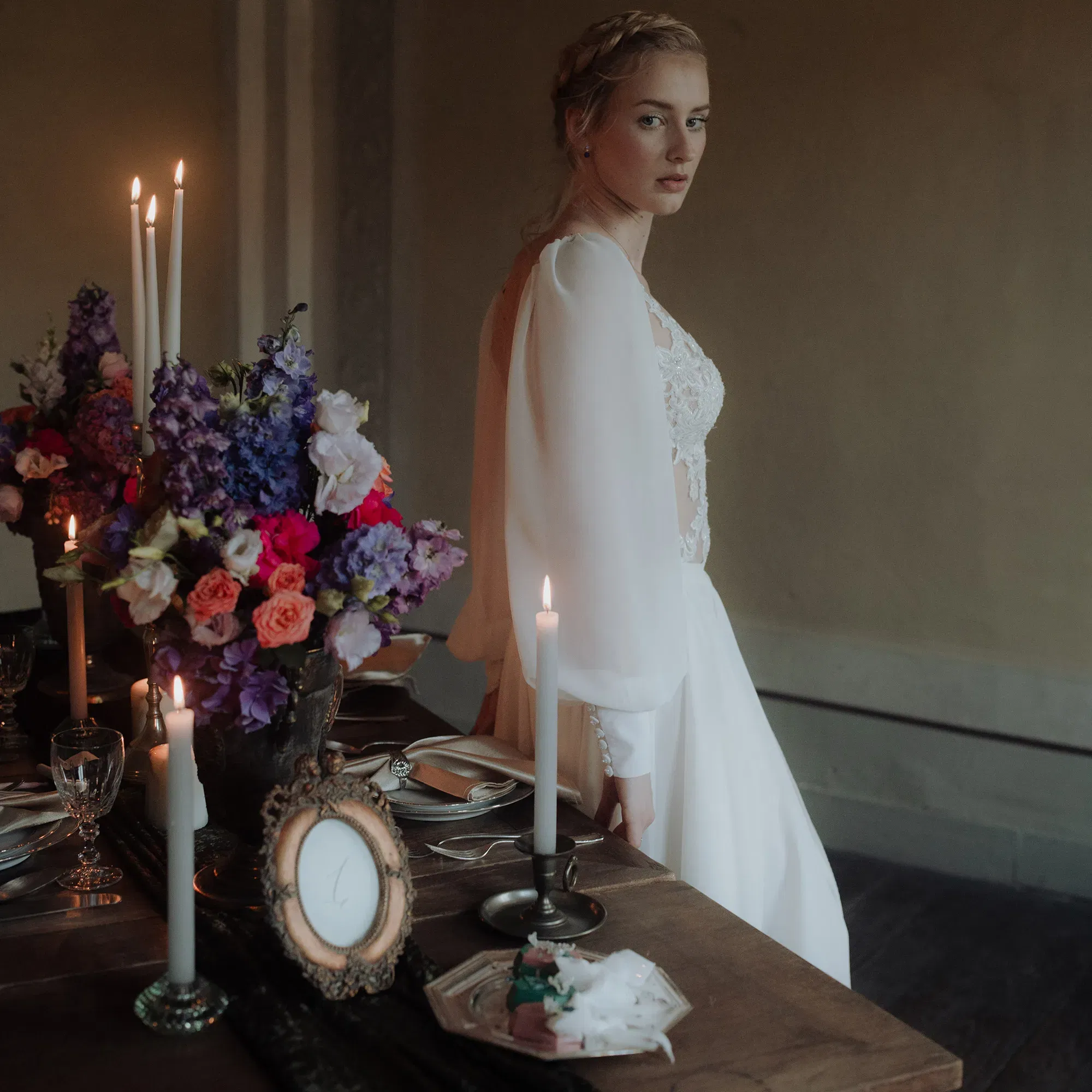 Braut im Hochzeitskleid vor gedecktem Tisch - Hochzeitsdeko im Kunst-Stil