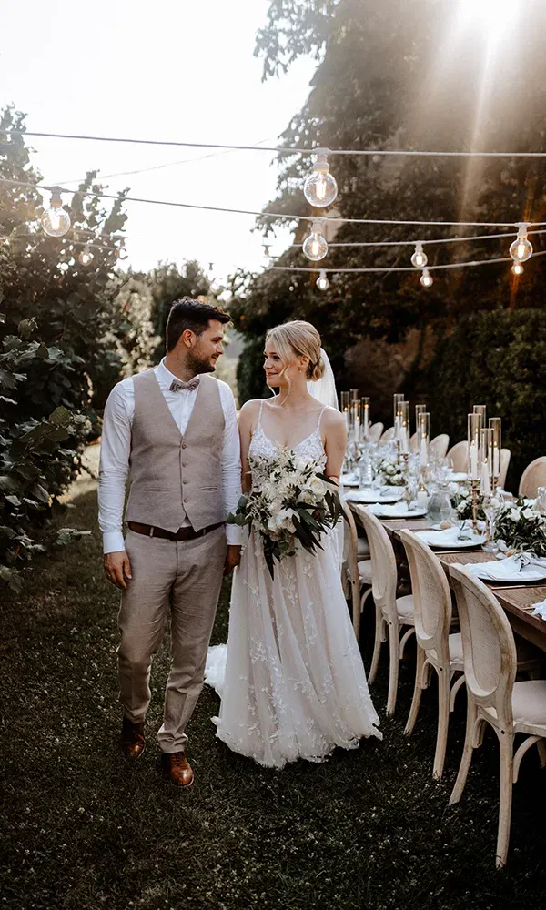 Hochzeitpaar in einem Garten vor einem gedeckten Tisch