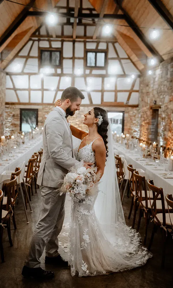 Hochzeitpaar in einem Festsaal mit gedeckten Tischen