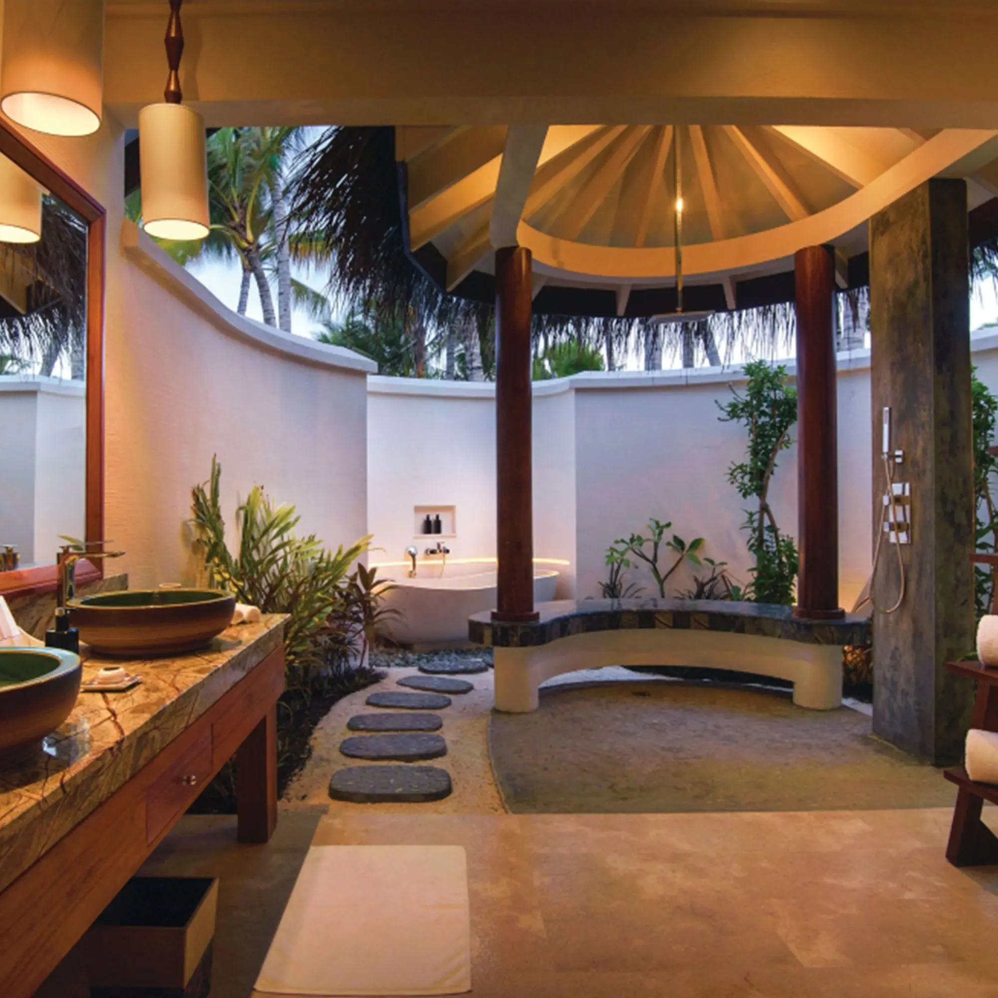 Geräumiges, offenes Badezimmer in einer Deluxe Strandvilla mit natürlichen Materialien, einer freistehenden Badewanne und einer tropischen Außendusche.