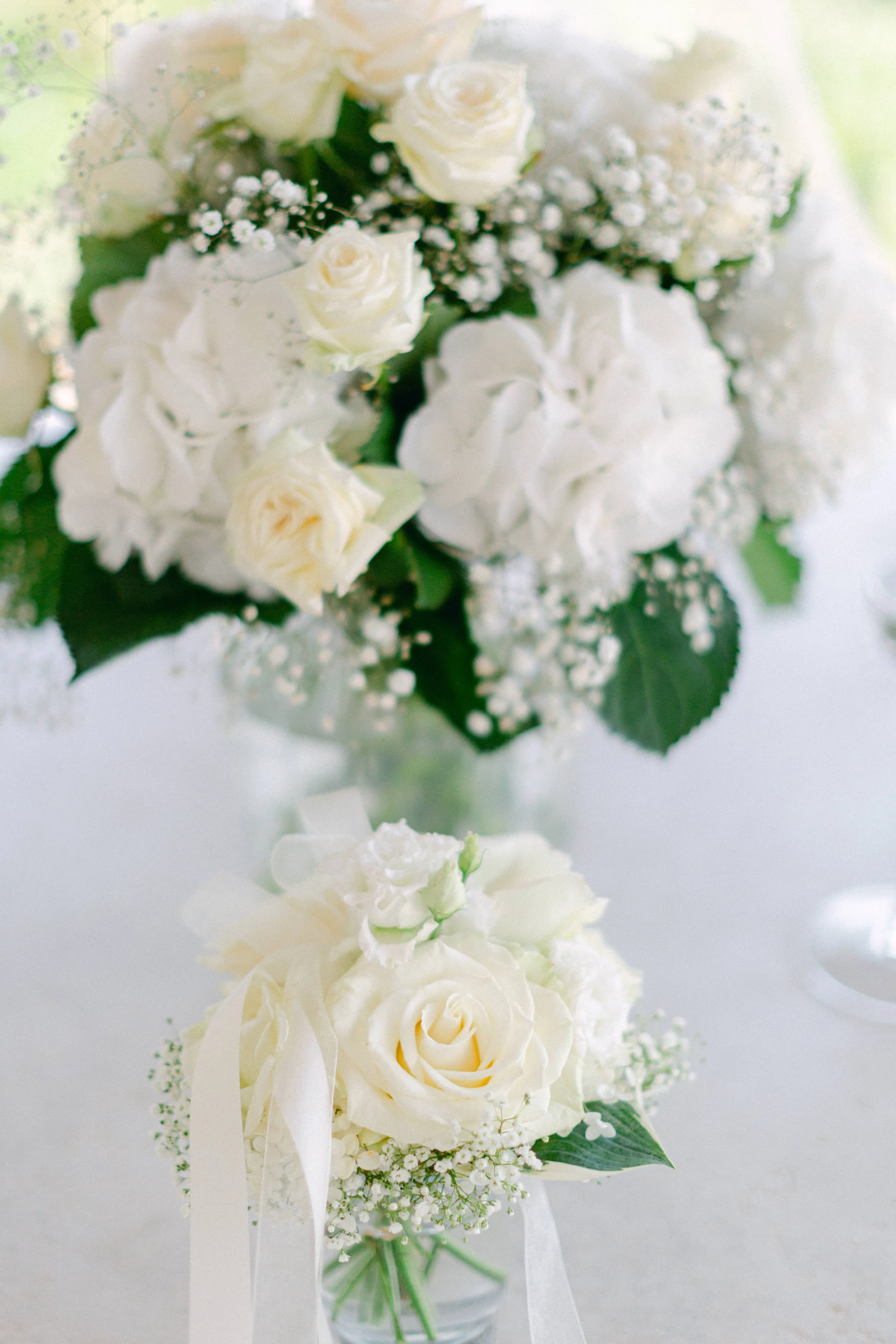 Ein eleganter Brautstrauß aus weißen Rosen und Schleierkraut, arrangiert für eine romantische Hochzeit.