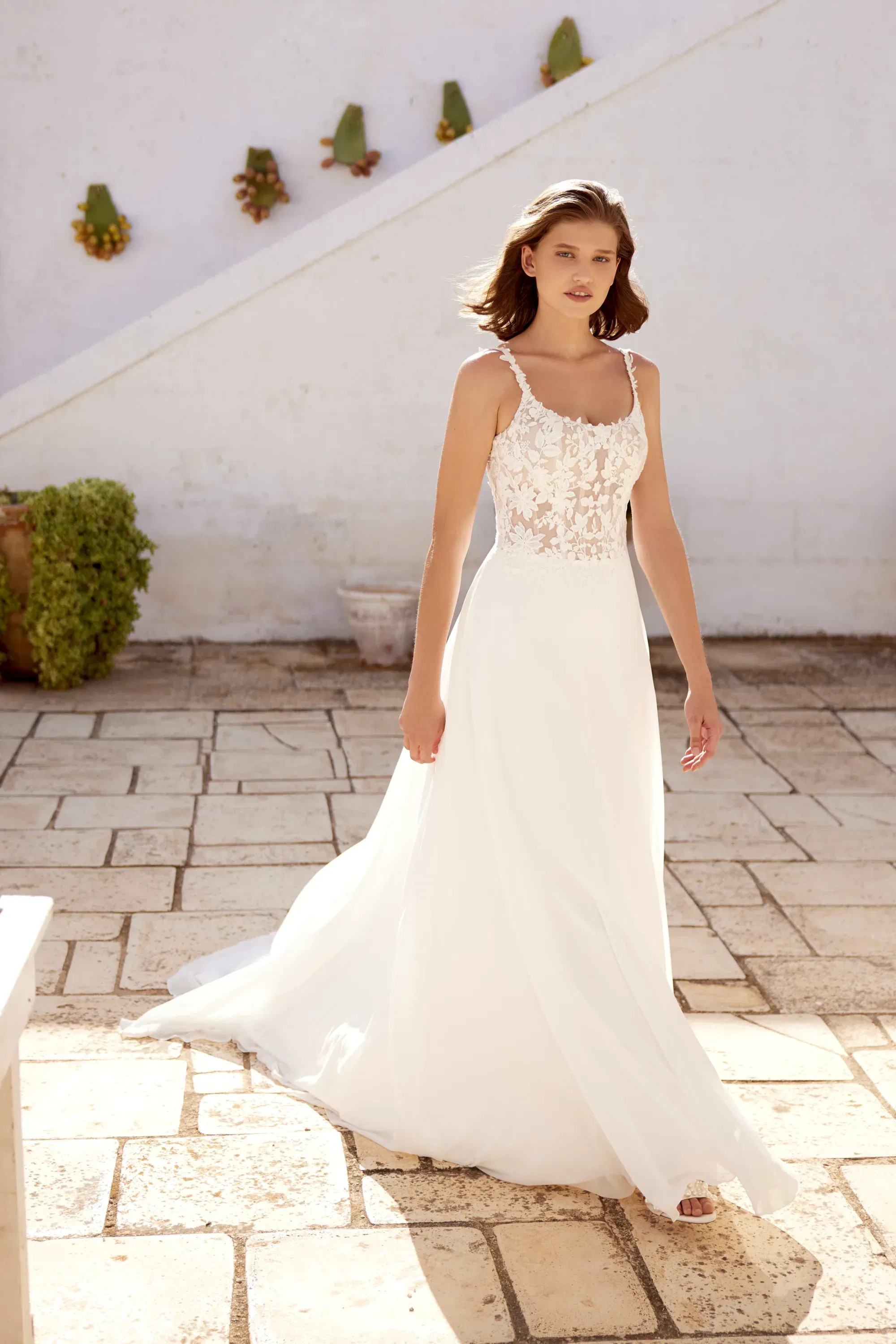 Fließendes Brautkleid mit langen Spitzenärmeln, tiefem Ausschnitt und eleganter A-Linien-Silhouette – Boho-Glam in Perfektion.