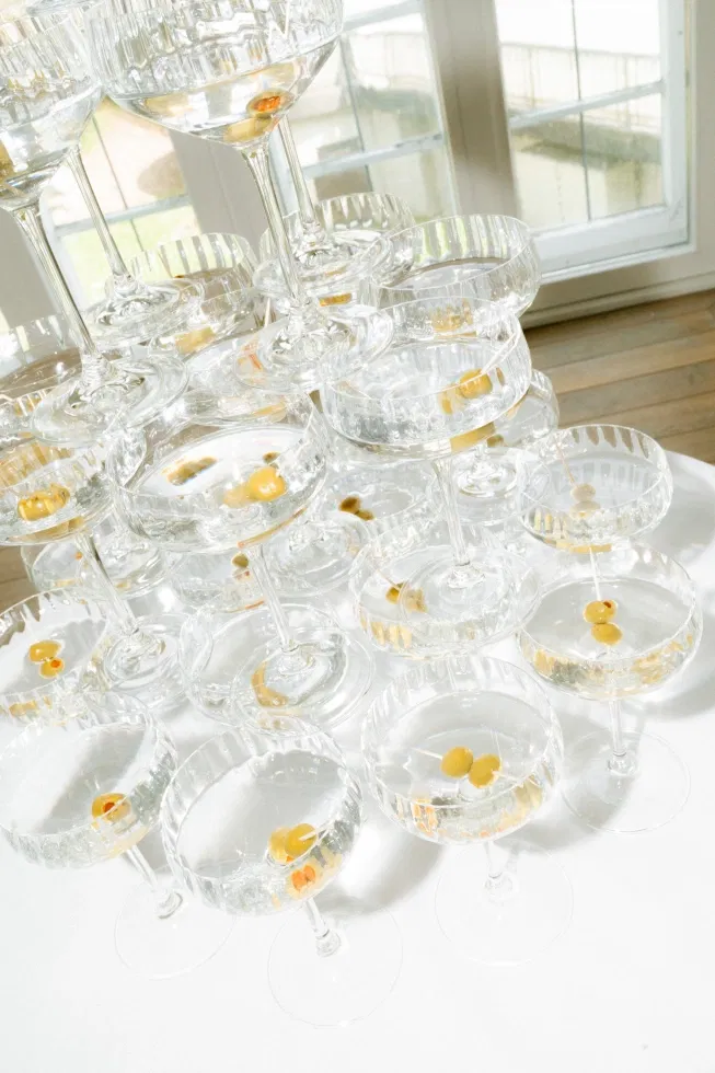 Eleganter Champagner- oder Martini-Turm mit Kristallgläsern und Oliven als stilvolles Highlight einer Schlosshochzeit.