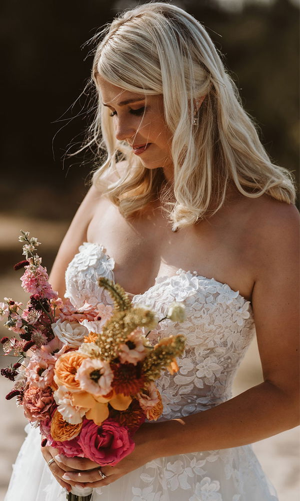 Porträt einer Braut mit strahlendem Brautstrauß und elegantem Styling.