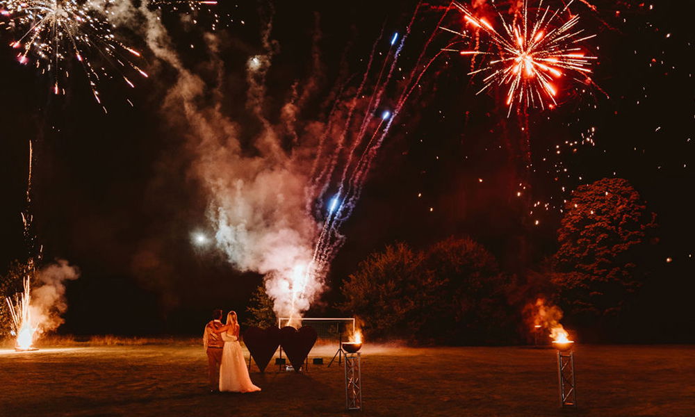 Leuchtendes Feuerwerk am Nachthimmel als krönender Abschluss der Hochzeitsfeier.