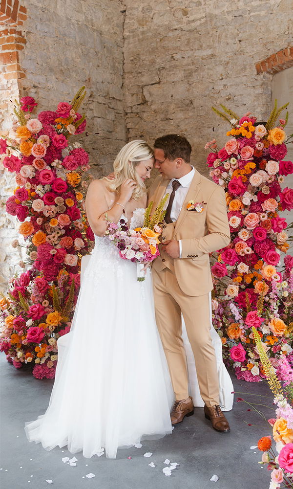 Brautpaar betrachtet ein farbenfrohes Feuerwerk, umgeben von romantischer Beleuchtung.