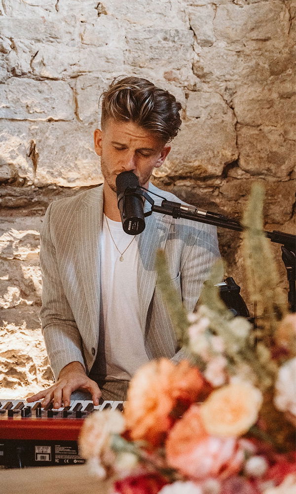 Sänger und Pianist in einer emotionalen Performance auf einer Hochzeit.