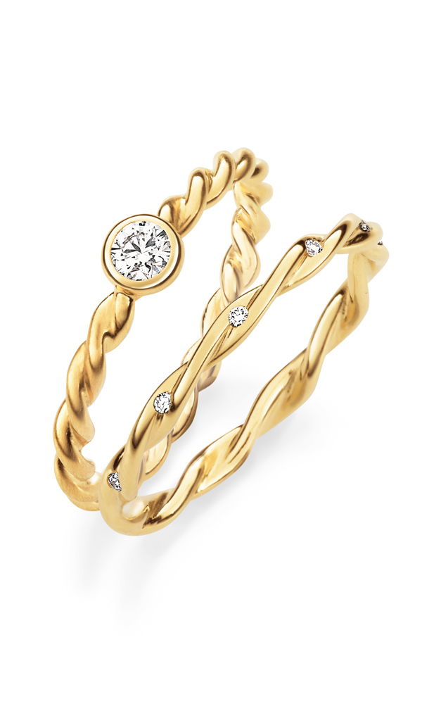Zwei raffinierte Kordelringe aus Gelbgold mit filigranen Details. Einer der Ringe besitzt einen zentral eingefassten Brillanten, während der andere mit mehreren kleinen Diamanten entlang des gewundenen Designs funkelt.