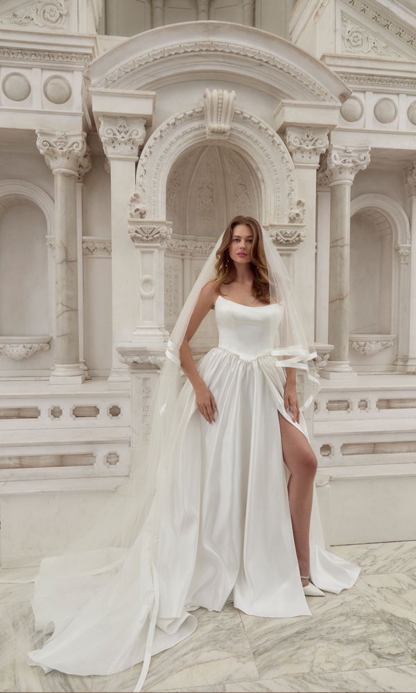 Romantisches Kleid mit fließendem Satinrock und zeitlosem Design, kombiniert mit einem eleganten Hintergrund aus weißem Marmor.