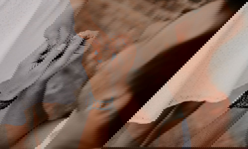 Detailaufnahme eines Mannes, der einen Verlobungsring an den Finger einer Frau steckt, eingefangen in einem emotionalen Moment.