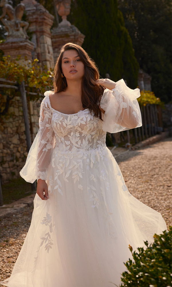 Boho-inspiriertes Hochzeitskleid mit aufwendiger Blattstickerei, zarten langen Ärmeln und einem sanft fallenden Tüllrock. Perfekt für eine natürliche Outdoor-Hochzeit.