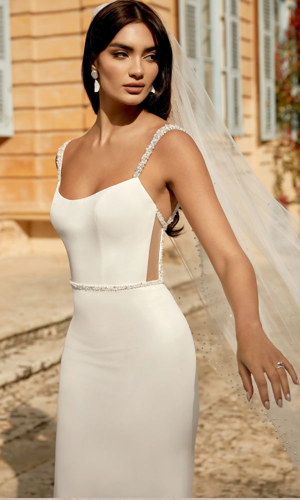 Schlichtes und modernes Hochzeitskleid mit perlenbesetzten Trägern und figurbetontem Schnitt, das Eleganz und Minimalismus vereint.