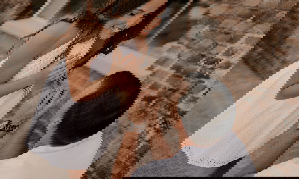 Emotionale Szene: Ein Mann kniet vor einer Frau im weißen Kleid, sie strahlt vor Freude, während er ihr einen Verlobungsring anbietet.