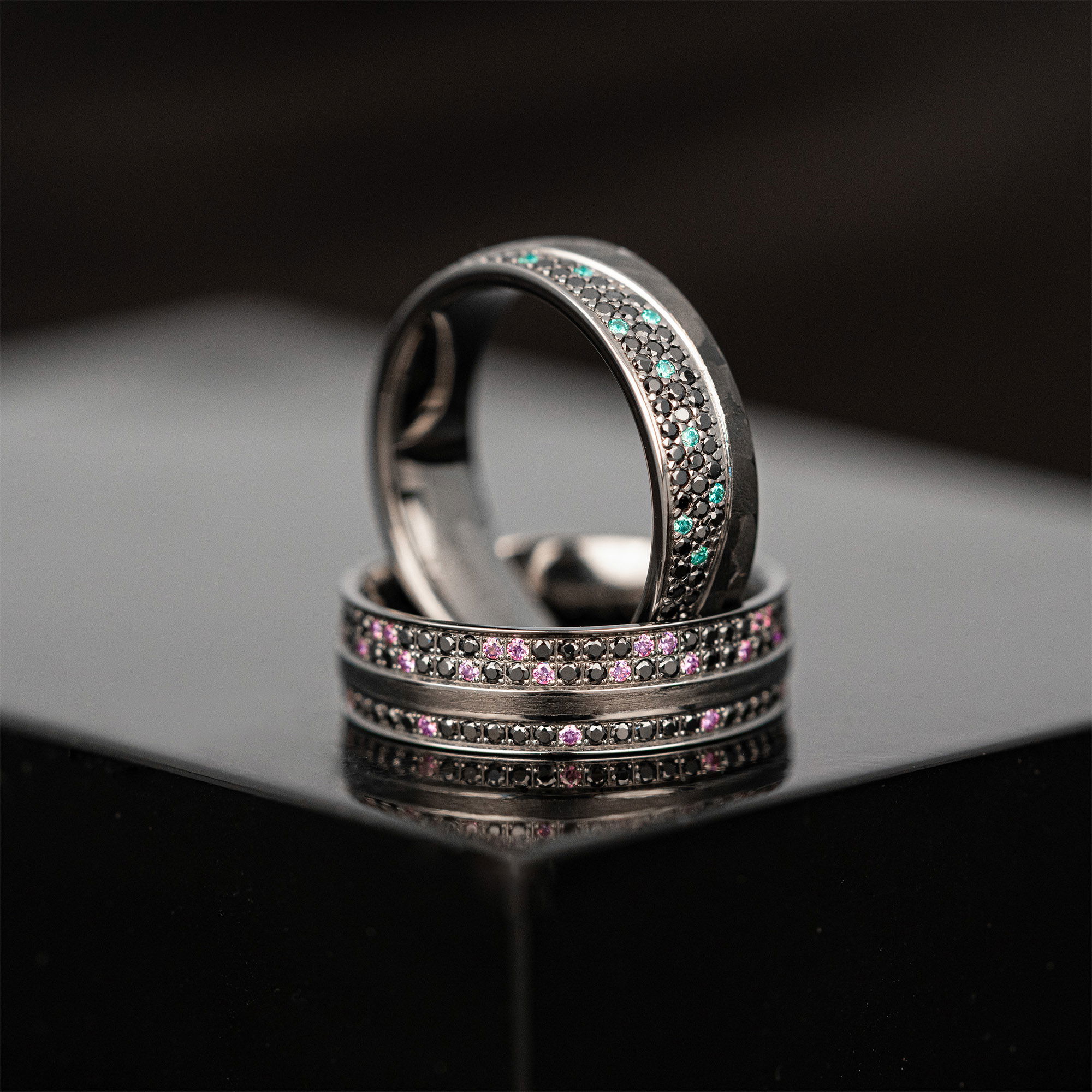 Moderne schwarze Eheringe mit farbigen Details in einem minimalistischen Design.