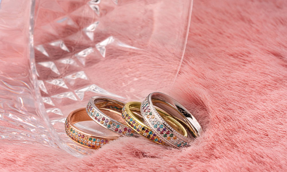 Luxuriöse Memoireringe mit farbigen Steinen, kreativ arrangiert auf einem Fell.