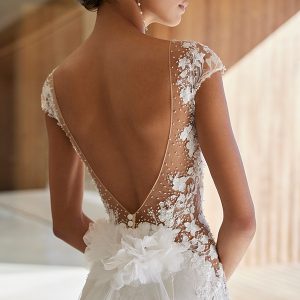 Romantisches Hochzeitskleid mit durchsichtiger Spitze, Perlendetails und raffinierter Rückenansicht.