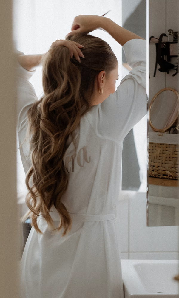 Momentaufnahme beim Getting Ready – die Braut richtet ihre Frisur.