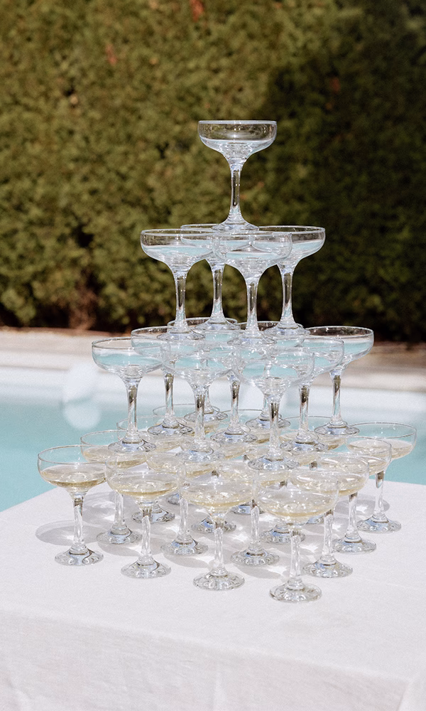 Stapel aus Champagnergläsern auf weißem Tisch – ein Highlight für die Hochzeit.