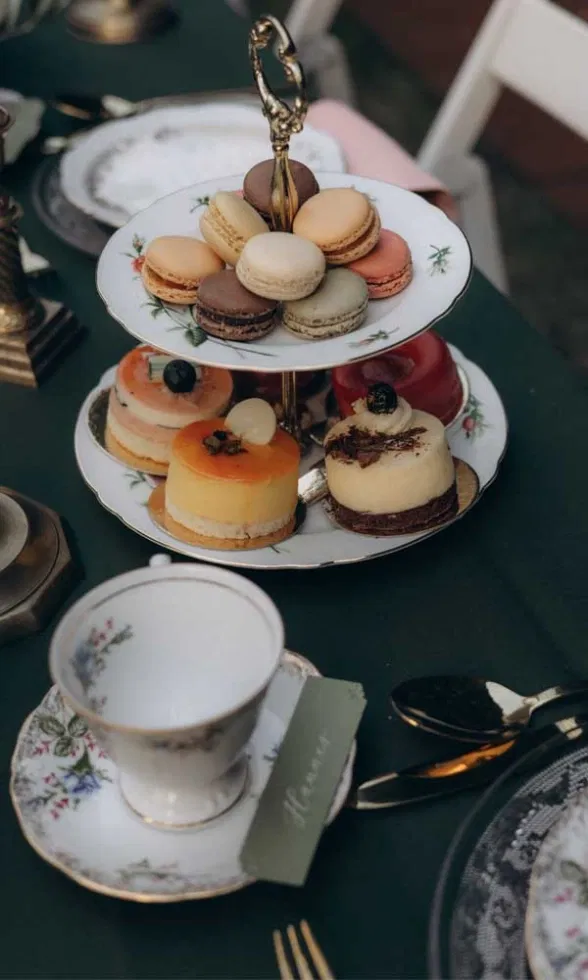 Elegante Sweettable-Etagere mit bunten Macarons und Mini-Törtchen auf einer stilvollen Tea-Time-Hochzeitstafel.
