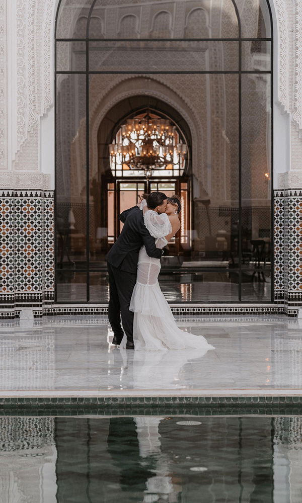 Bräutigam hebt seine Braut zum Kuss auf einer edlen Marmorfläche.