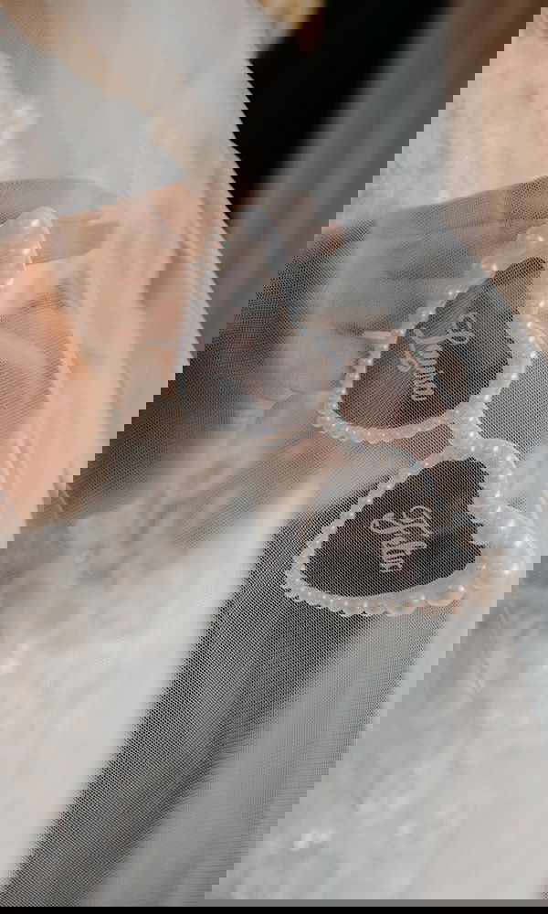 Detailaufnahme einer Sonnenbrille mit den Namen „Laura“ und „Felix“ als Hochzeitsaccessoire.