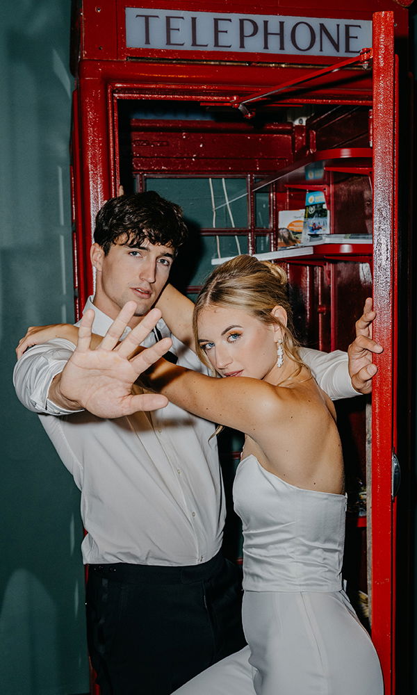 Braut und Bräutigam in cooler Pose mit urbanem Vibe vor einem kultigen Fotospot.