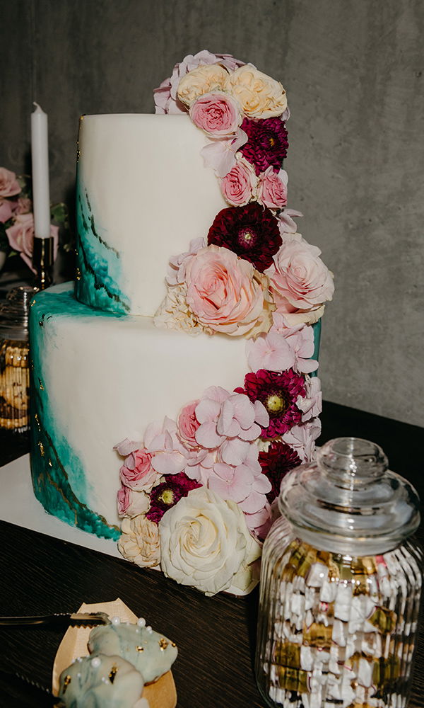 Elegante Torte mit echten Blumen und feinem Farbverlauf in Türkis.