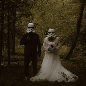 Star Wars Brautpaar in Kostüm und Hochzeitskleidung zwischen Bäumen