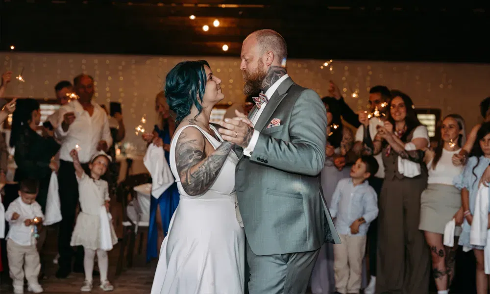 Der Hochzeitstanz des Brautpaares in stimmungsvoller Atmosphäre, begleitet von leuchtenden Wunderkerzen und begeisterten Gästen.