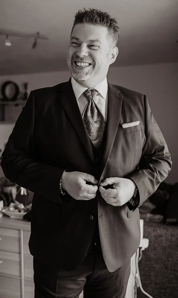 Fröhlicher Bräutigam zieht sich an, bereit für den großen Moment.