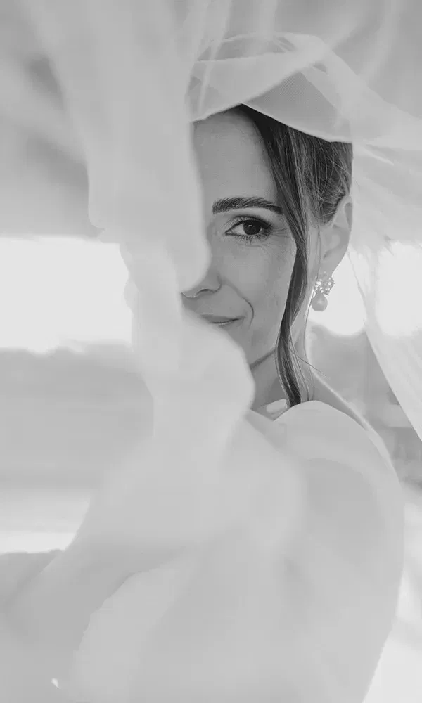 Intimes Porträt einer Braut unter dem Schleier in Schwarz-Weiß.