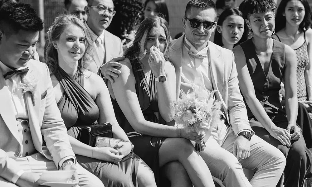 Eine Hochzeitsgästen wird während der Zeremonie von ihren Emotionen überwältigt.