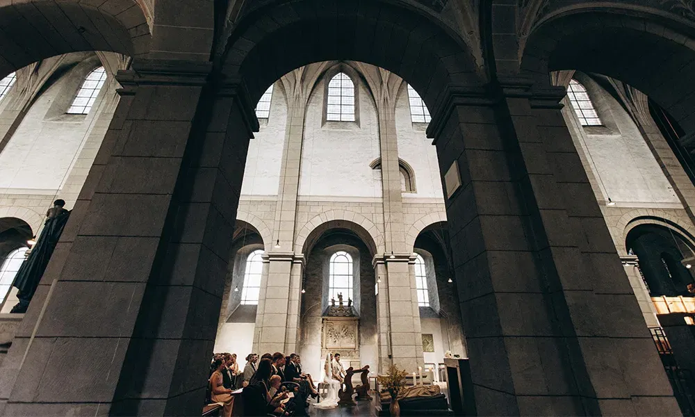 Majestätische Perspektive einer kirchlichen Trauung mit Blick auf das Brautpaar am Altar.