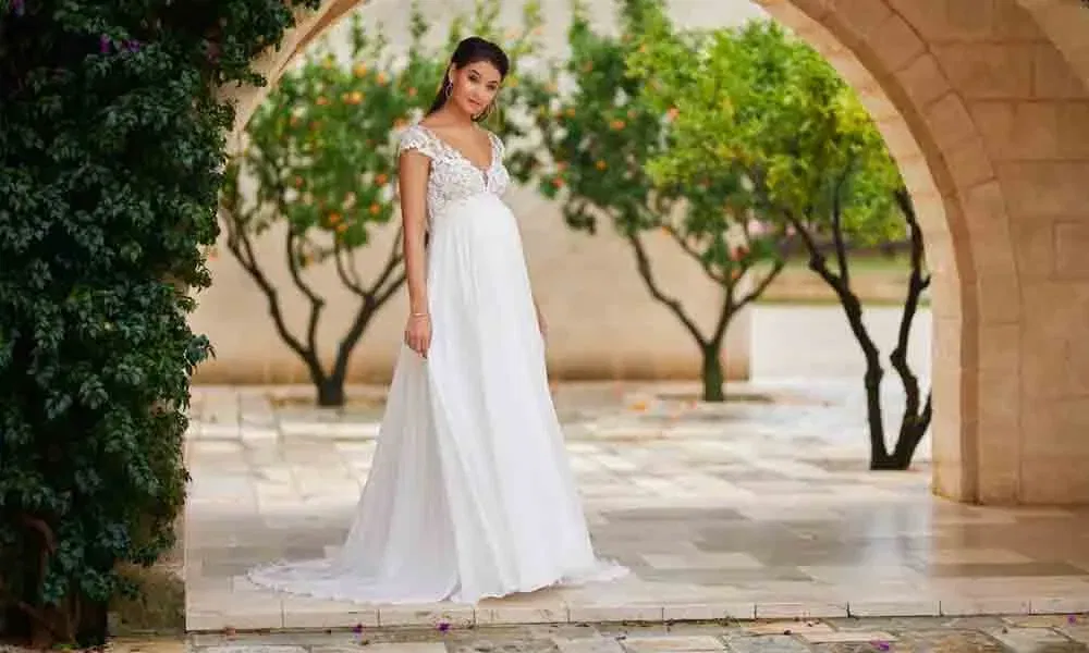 Romantisches Hochzeitskleid mit fließendem Rock und besticktem Ausschnitt – fotografiert in mediterraner Hofkulisse.