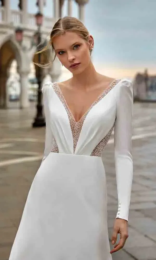 Figurbetontes Hochzeitskleid mit tiefem Ausschnitt und glitzerndem Mesh im Dekolleté.