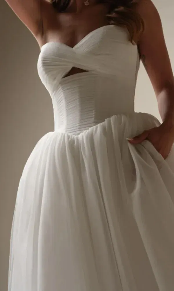 Detailaufnahme eines eleganten Tüll-Ballkleids mit überkreuztem Corsagenoberteil und ausgestelltem Rock.