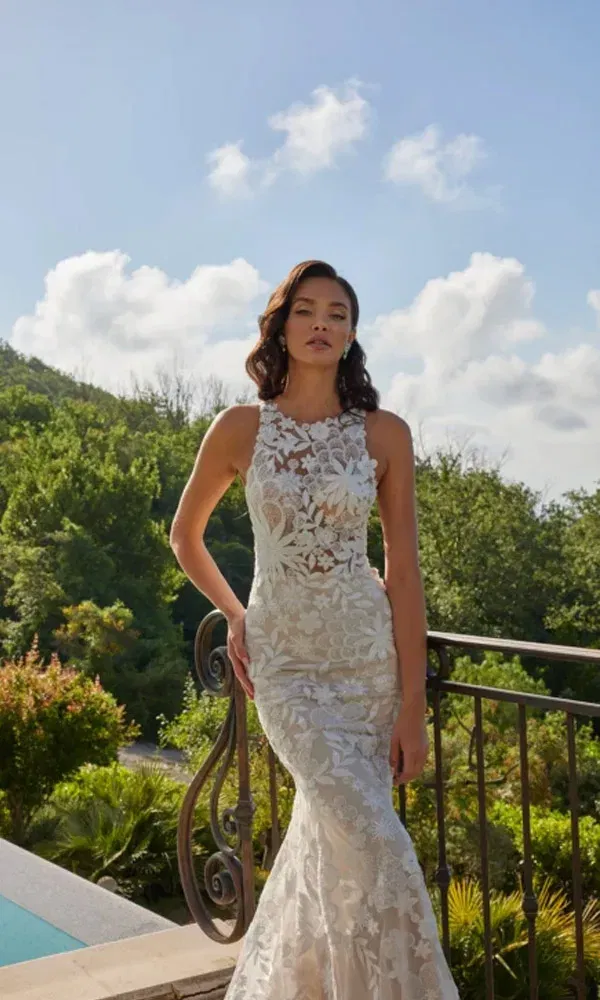 Elegantes Brautkleid mit transparentem Spitzenoberteil und engem Schnitt – fotografiert vor Pool und Waldkulisse.