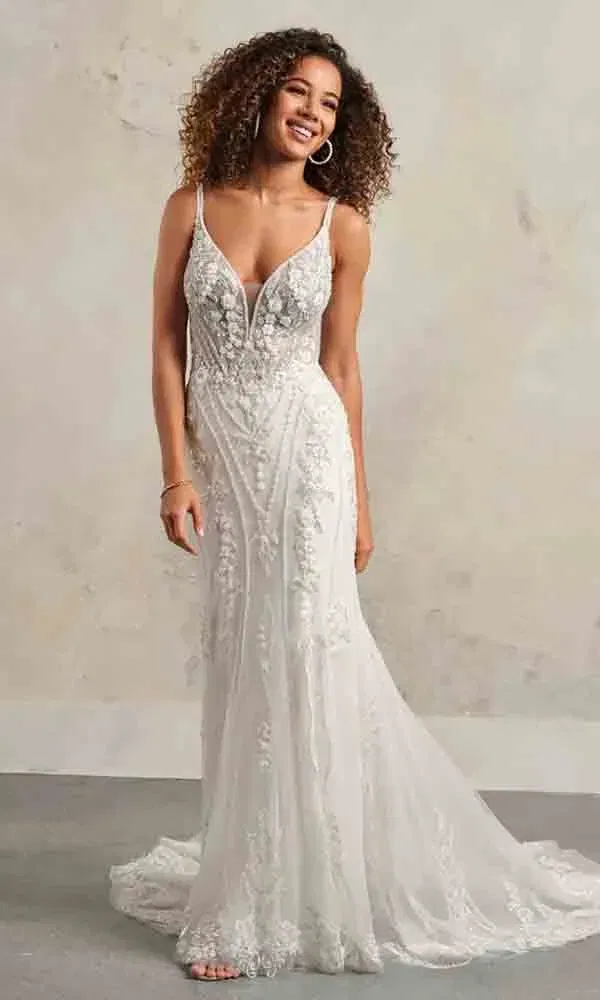 Braut mit natürlichem Look in einem luftigen, spitzenbesetzten Hochzeitskleid mit Trägern und eleganter Silhouette.