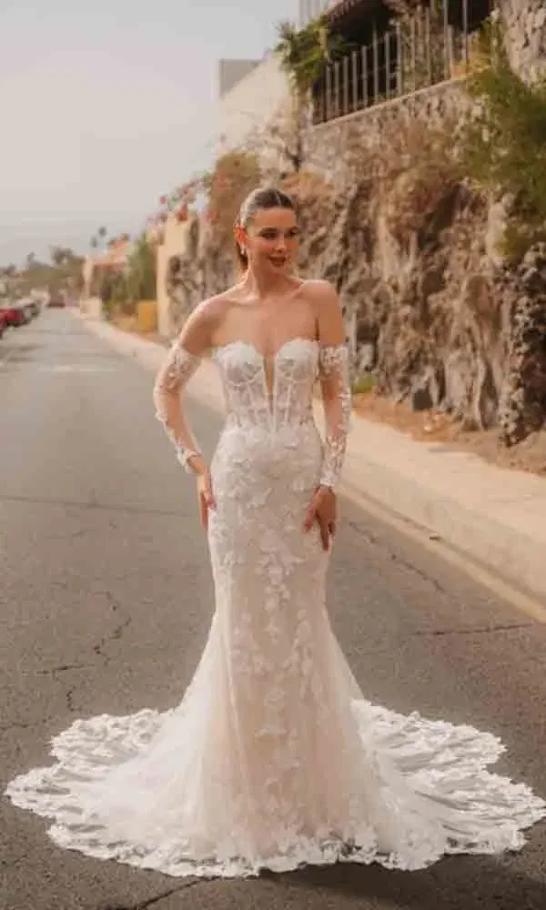 Romantisches Fit-and-Flare-Hochzeitskleid mit floraler Spitze, lange Ärmel, aufgenommen bei natürlichem Tageslicht.