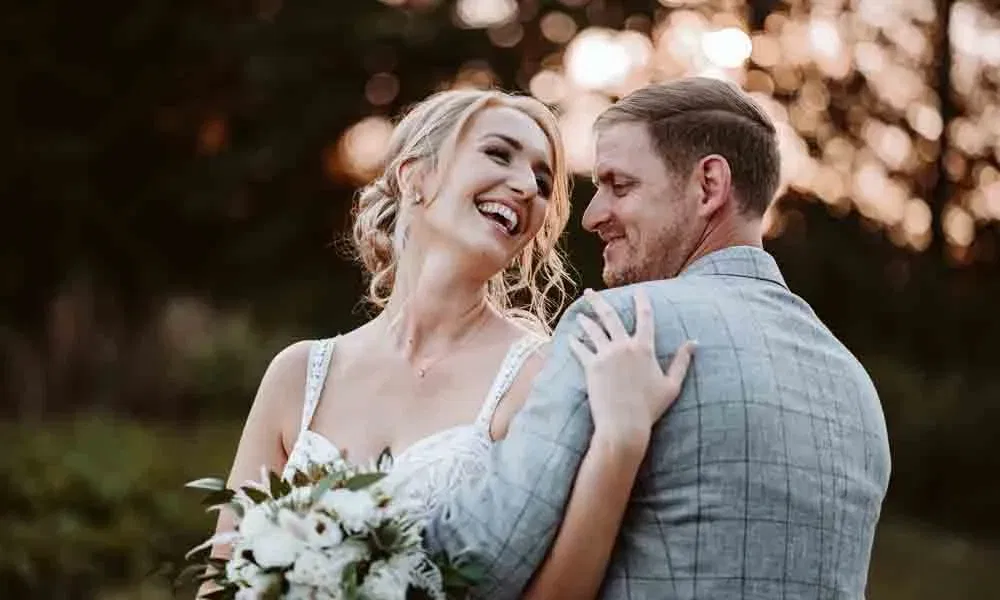 Sophie und Reinhard genießen einen innigen Moment im Abendlicht – sie blickt lachend über die Schulter.