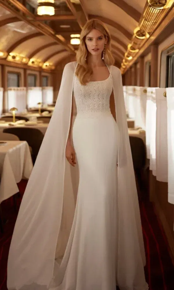 Schlichtes und modernes Hochzeitskleid mit schmaler Silhouette und Spitzenmieder, kombiniert mit einem dramatischen Chiffon-Cape.