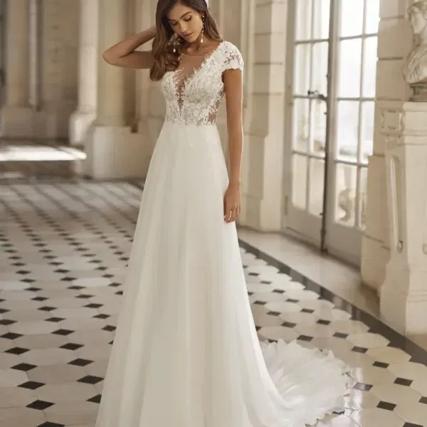 Romantisches A-Linien-Hochzeitskleid mit Spitzenoberteil und zartem Chiffonrock, getragen von einer Braut in einer hellen, klassisch-eleganten Location.