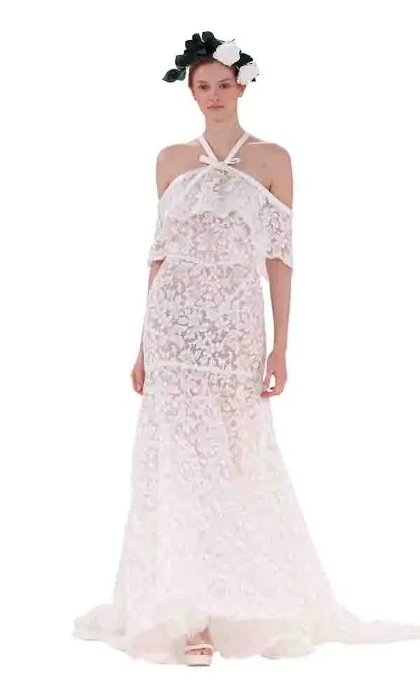 Elegantes Hochzeitskleid aus transparenter Spitze mit Boho-Flair und floraler Kopfbedeckung.