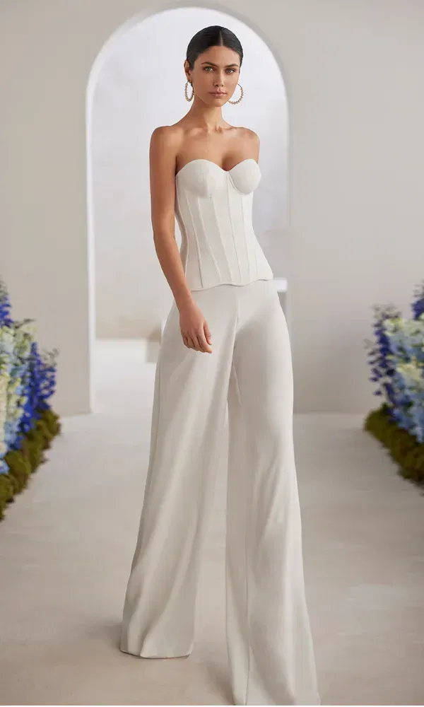 Eleganter Hochzeits-Jumpsuit mit figurbetontem Corsagen-Top und fließender Hose im minimalistischen Stil.